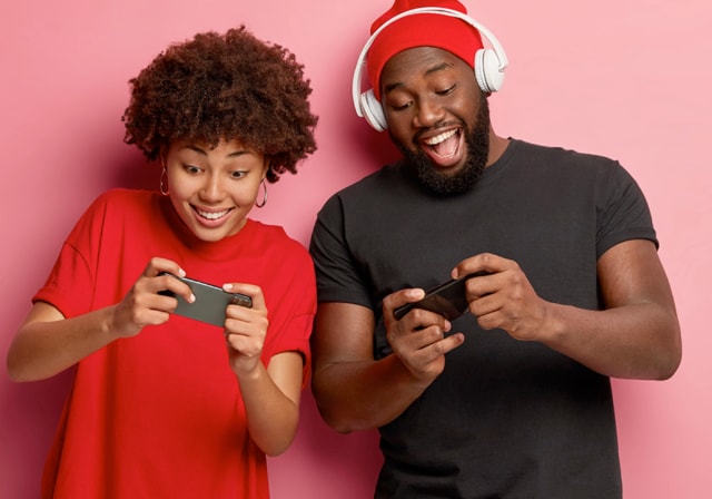 Dos jugadores disfrutando de un juego en sus teléfonos.