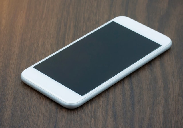 Un iPhone blanco sobre una mesa se está intercambiando.