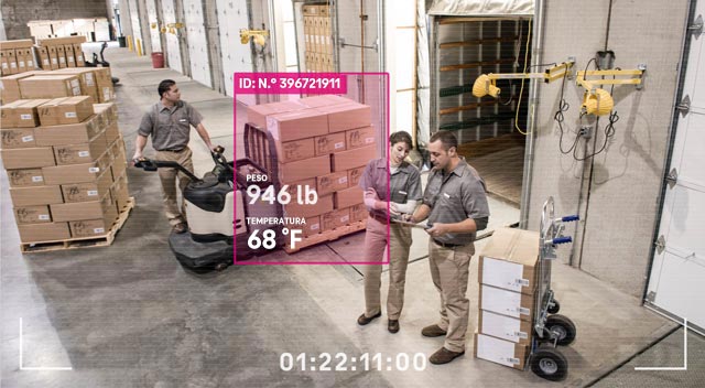 Vista de videocámara de tres empleados de depósito consultando formularios y trasladando cajas con datos de identificación, peso y temperatura superpuestos sobre la imagen.