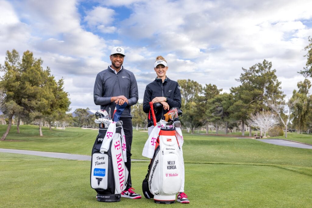 Professional golfers Tony Finau and Nelly Kurda pose with golf bags on the golf course.