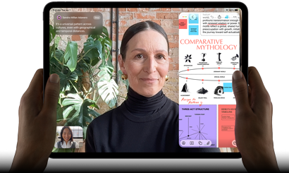 iPad Pro, exterior frontal, orientación horizontal, color negro espacial, esquinas redondeadas, bisel de pantalla negro, manos sosteniendo los lados derecho e izquierdo, pantalla que muestra una conversación en FaceTime que se traduce en vivo y una app educativa que muestra una presentación de "Comparative Mythology" con texto, diagramas y notas escritas a mano