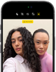iPhone 18 Pro, negro, exterior frontal, muestra a dos modelos posando para la cámara, donde se aprecia la cámara frontal Center Stage
