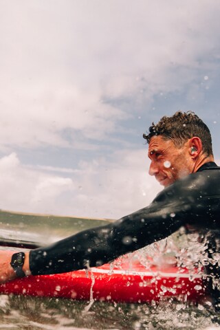 Un hombre practicando surf de remo en el agua con un Apple Watch Series 10