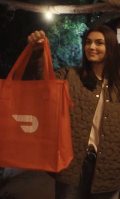 Mujer sosteniendo una bolsa de DoorDash
