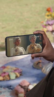 Persona sosteniendo un teléfono y viendo la serie Bridgerton