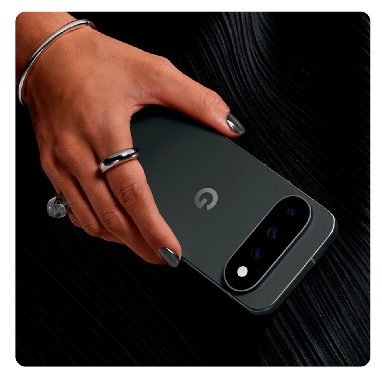 Primer plano de alguien sosteniendo un teléfono Google Pixel 11 Pro XL delante de un vestido de noche negro.