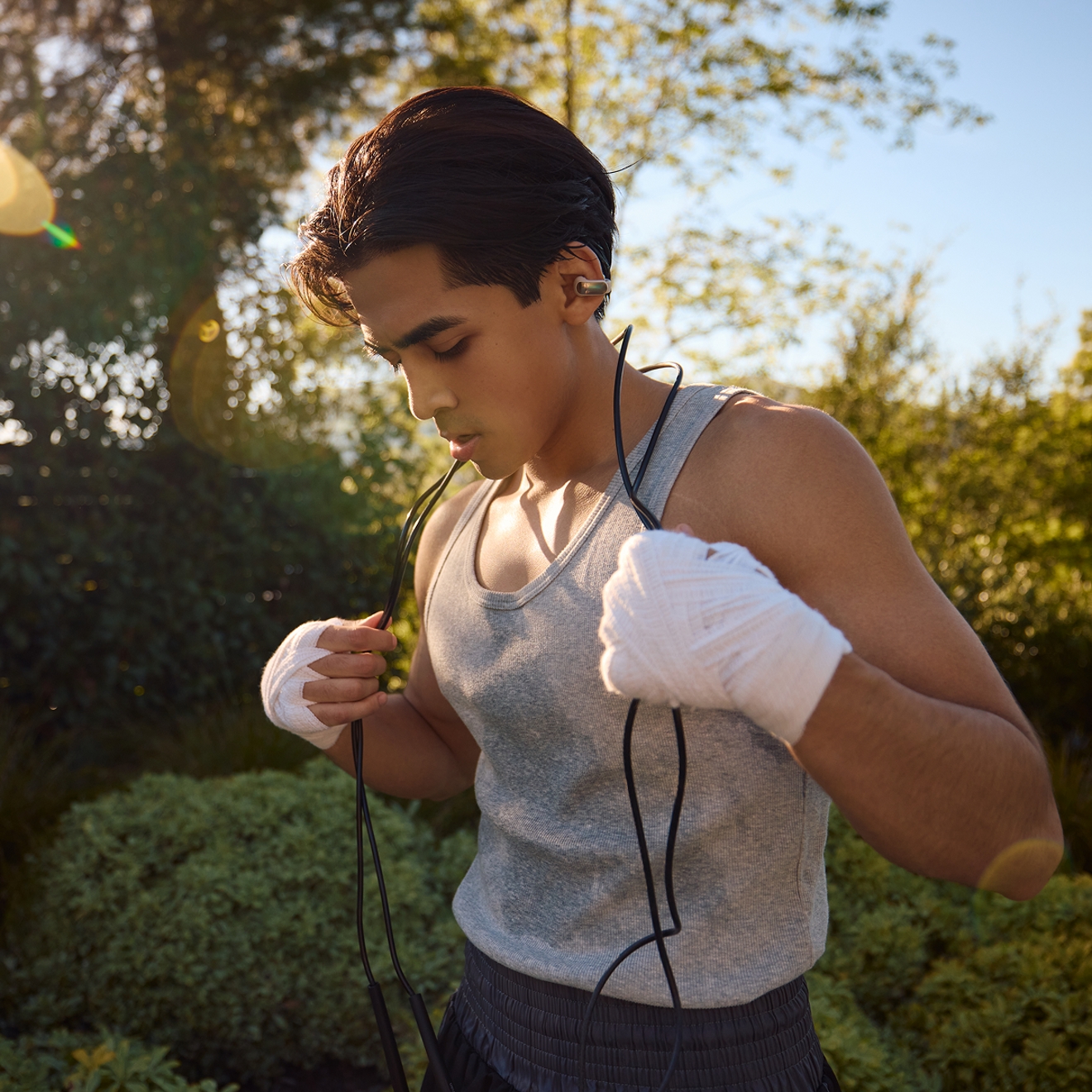 Hombre haciendo ejercicio con los audífonos abiertos Bose Ultra.