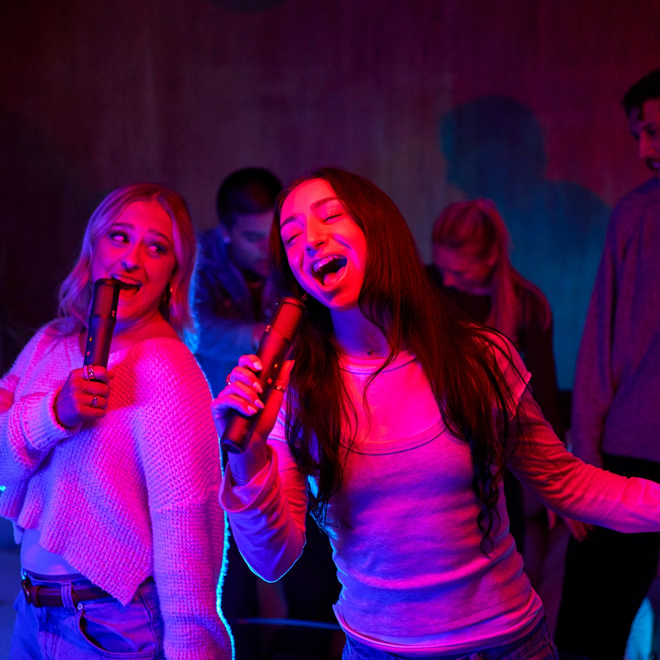 Dos mujeres cantan juntas con los micrófonos JBL Easy Sing 2.