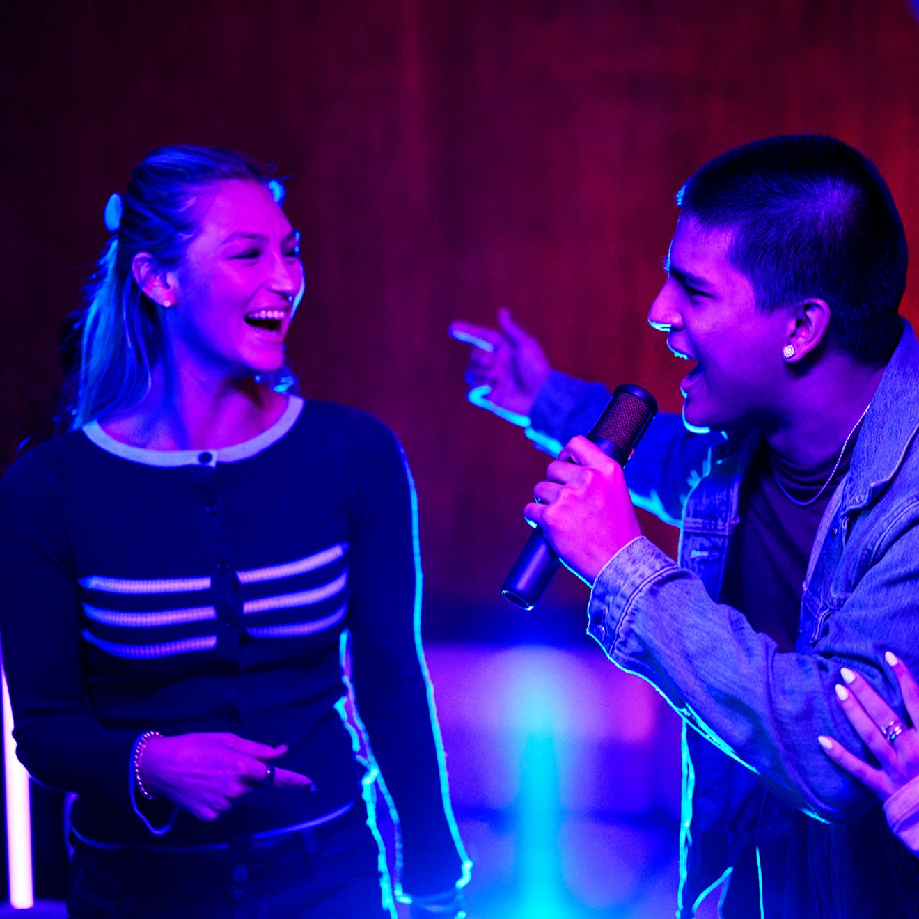Un hombre y una mujer cantan juntos con los micrófonos JBL Easy Sing 2.