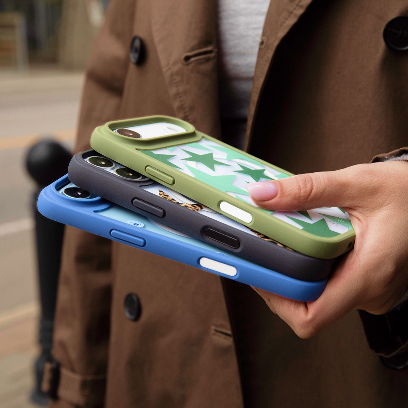 Un hombre sostiene tres fundas Pela para iPhone en una mano.
