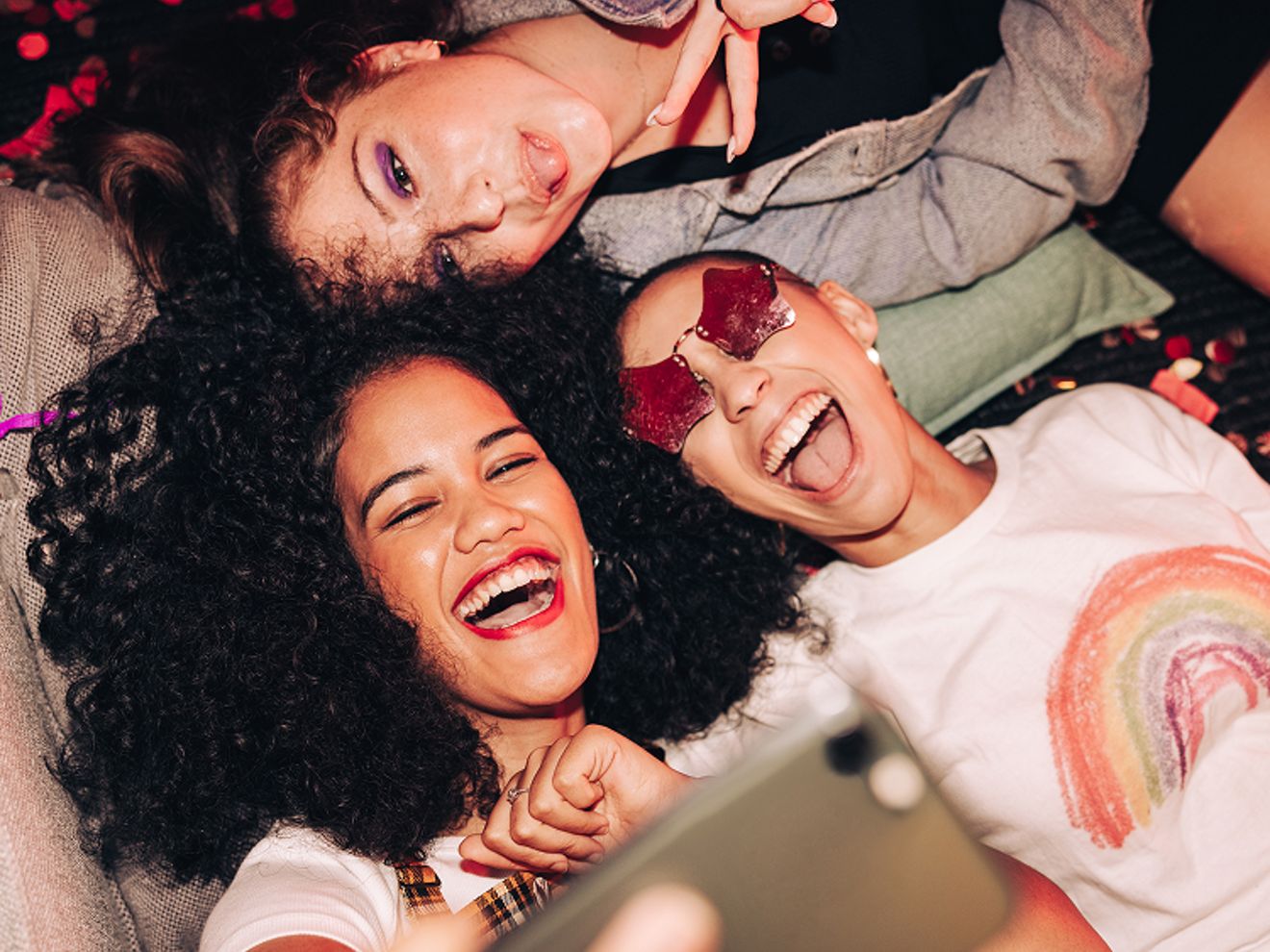 Tres amigos se toman un selfie en una fiesta.