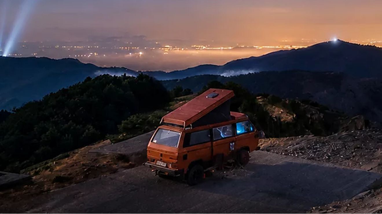 Una autocaravana estacionada en un acantilado al atardecer.