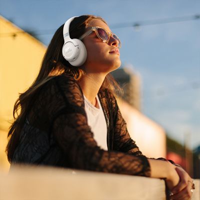 ​​​​​​​Una mujer escucha música con audífonos JBL 780NC.