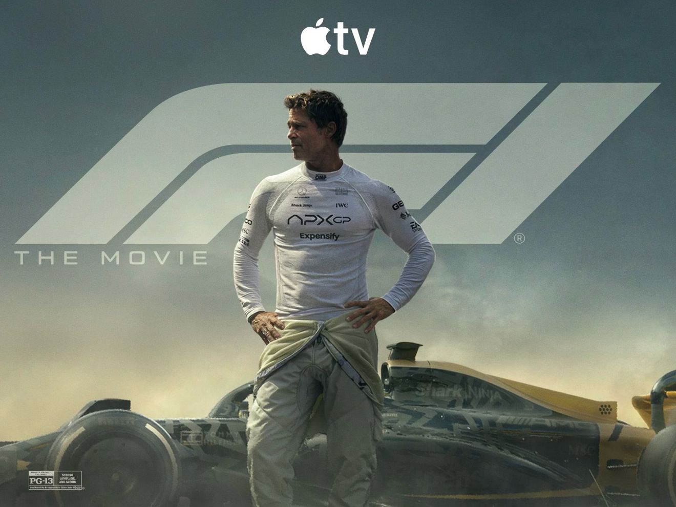 Hombre con un traje de carreras detrás de un auto de Fórmula 1 promocionando el contenido de Apple TV.