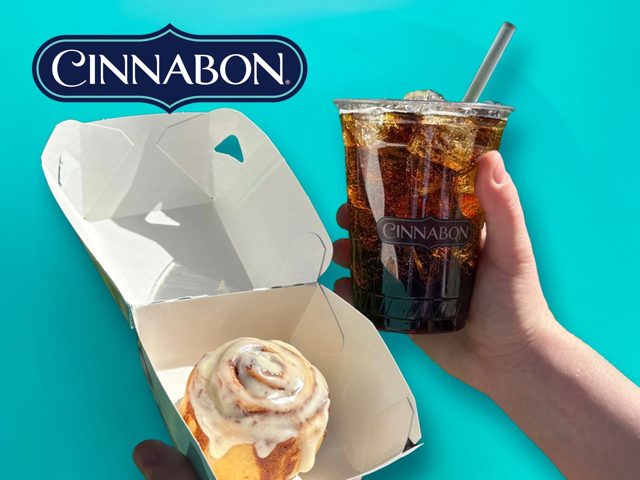 Un MiniBon de Cinnabon en una caja abierta, junto a una mano que sostiene una bebida de Cinnabon, sobre un fondo turquesa brillante.