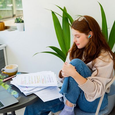 Una mujer lleva puestos los audífonos JBL Vibe Beam dos en su escritorio.
