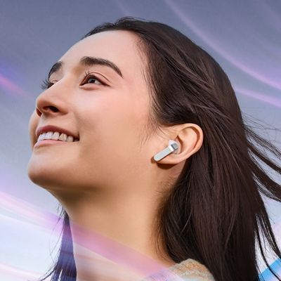 Una mujer, rodeada de ruido, escucha música con sus audífonos Samsung Galaxy Buds cuatro.