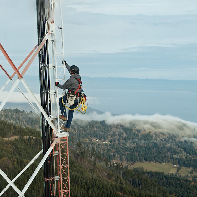 Un hombre subiendo a una torre celular.