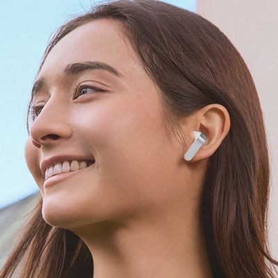 Una mujer lleva puestos unos audífonos Samsung Galaxy Buds cuatro.