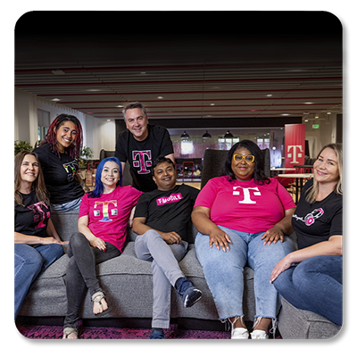Un grupo de empleados de T-Mobile sonríen sentados en un sofá.