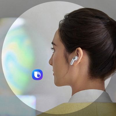 Una mujer sonríe mientras usa unos audífonos Samsung Galaxy Buds cuatro. Junto a ella aparece un ícono de asistente con un recuadro circular.