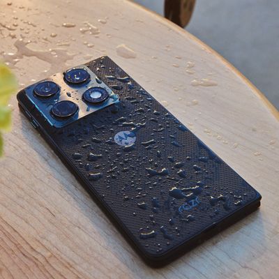 Motorola razr Fold desde un ángulo trasero sobre una mesada, con gotitas de agua que destacan el acabado rugoso y el módulo de dos cámaras.