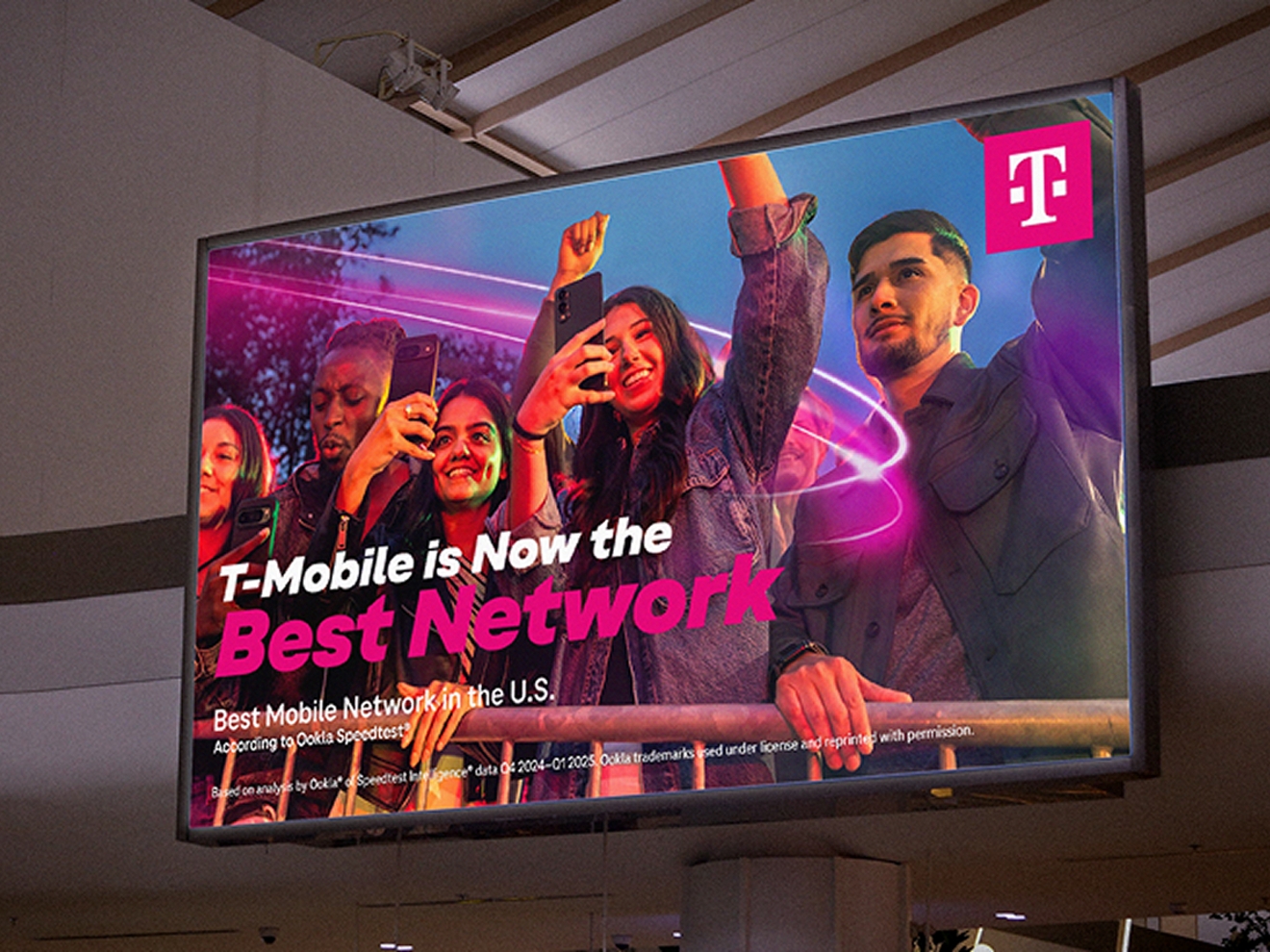 Una gran pantalla digital muestra a los clientes celebrando que T-Mobile es ahora la mejor red.
