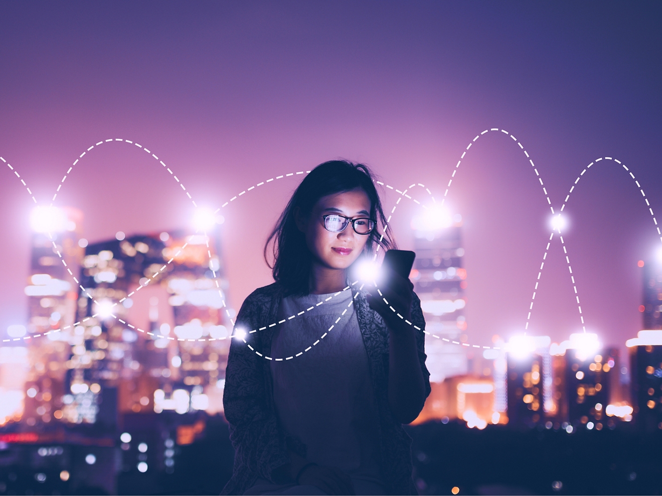 El smartphone de una mujer se conecta con dos vías de luz que se cruzan y la rodean.