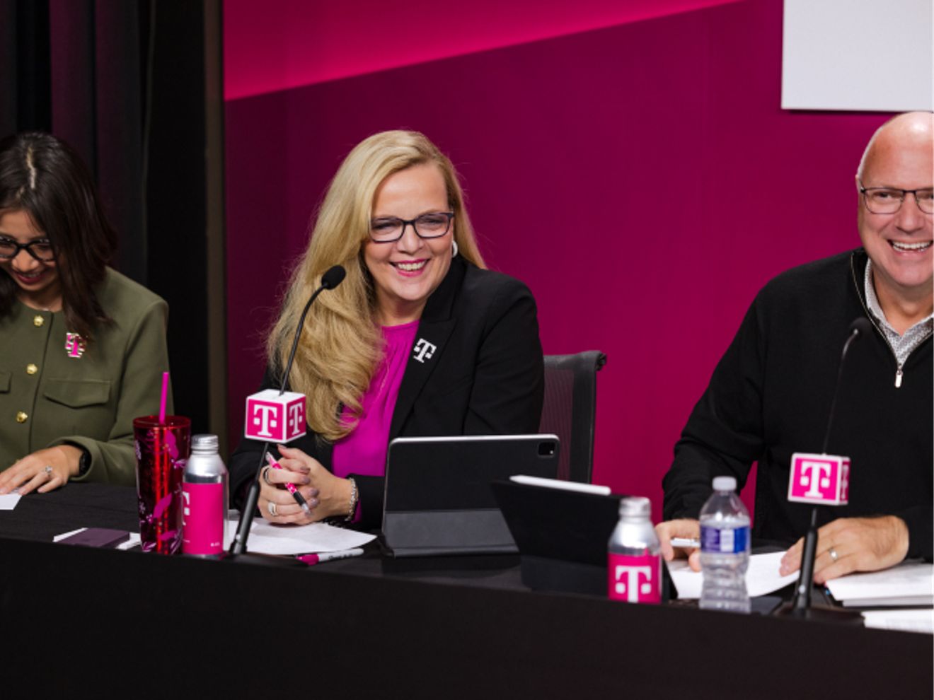 Janice sentada con los miembros del equipo directivo, sonriendo.