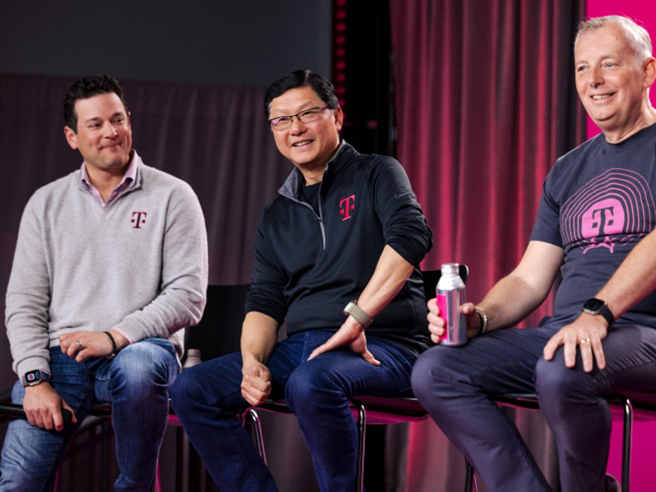 John sentado con los miembros del equipo directivo, sonriendo.
