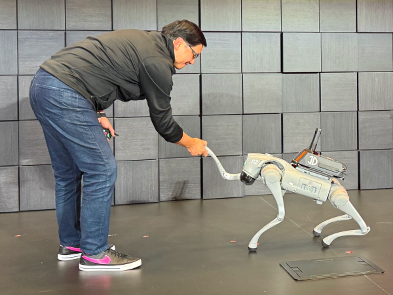 John estrechando la mano de un robot de cuatro patas.