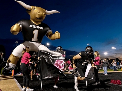 Varios estudiantes sostienen una mascota inflable gigante de los Longhorn.