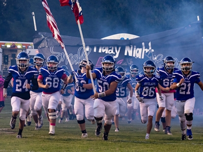 Varios estudiantes sostienen una mascota inflable gigante de los Longhorn.