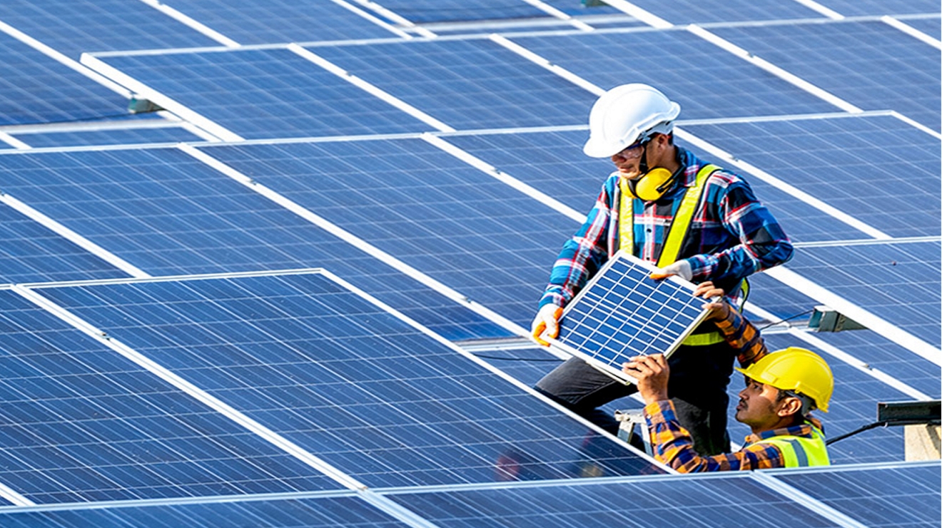 Dos trabajadores instalando paneles solares en una granja solar