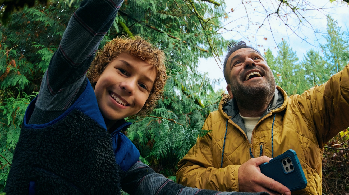 Primer plano de un padre y un hijo posando para una selfie en el bosque