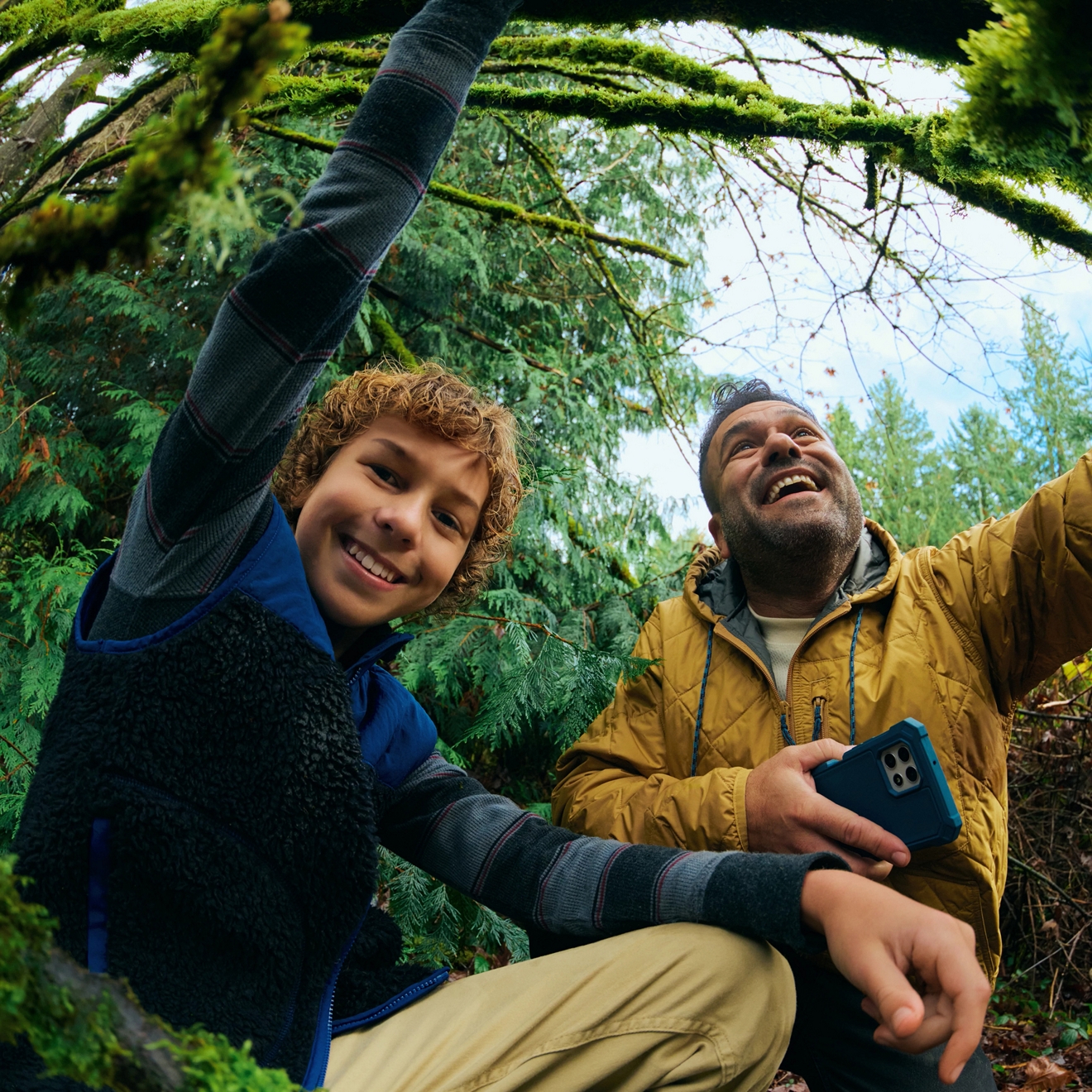 Primer plano de un padre y un hijo posando para una selfie en el bosque