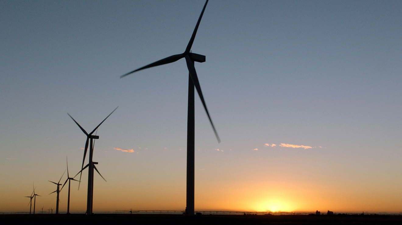 Una hilera de aerogeneradores al anochecer