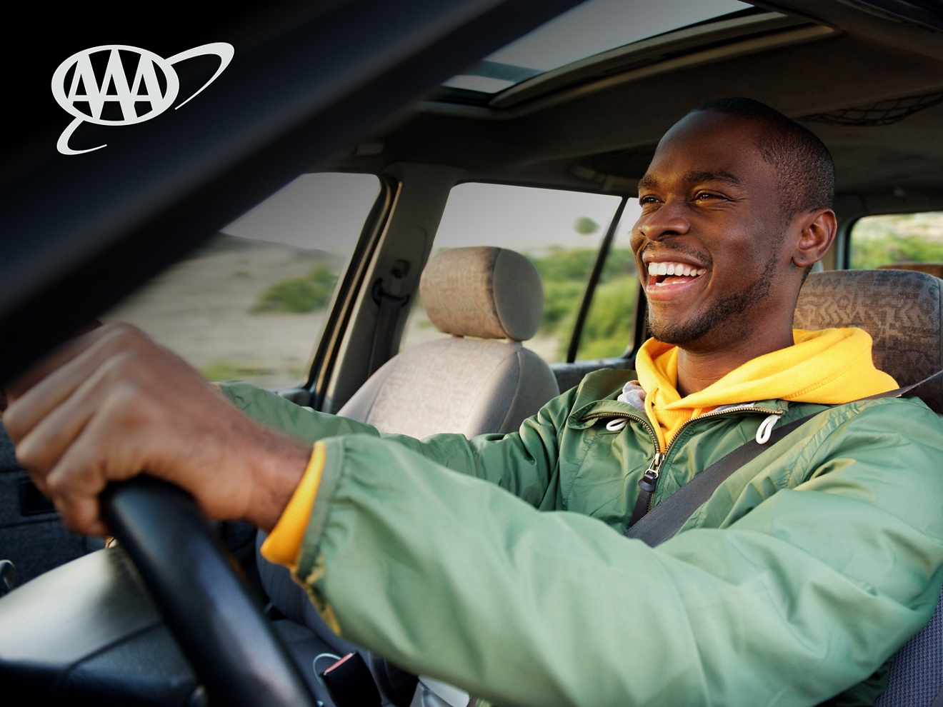 Persona conduciendo un auto con una gran sonrisa en la cara.