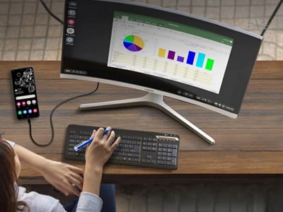 Un analista consulta gráficos y datos en la pantalla de una computadora de escritorio conectada a un dispositivo Samsung mediante Samsung DeX.