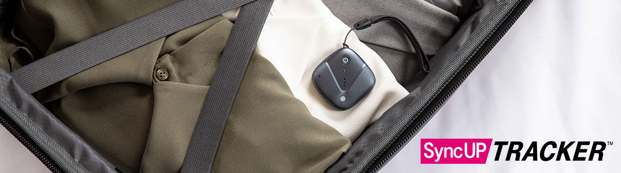 Dispositivo Sync-up tracker sobre ropa empacada en una maleta.
