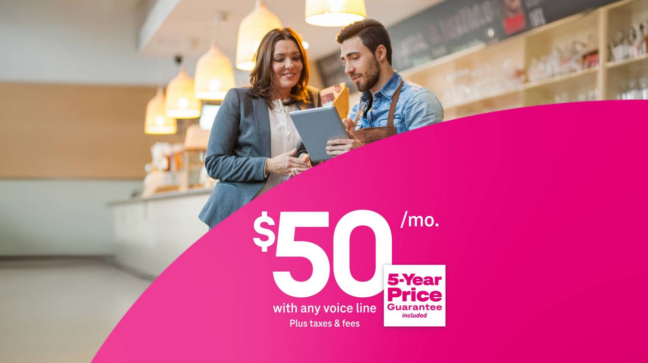 Dos profesionales de negocios revisan una tablet en una cafetería, encima de un texto que promociona $50 al mes con cualquier línea de voz, más impuestos y cargos, y precio garantizado por 5 años incluido.