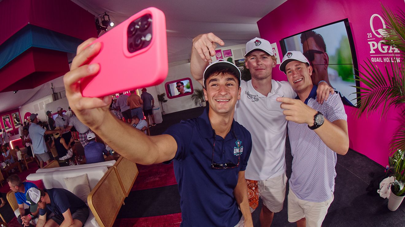 Tres miembros de T-Mobile posando para un selfie dentro del Club Magenta.