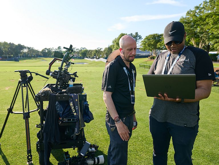Dos fotoperiodistas preparando su equipo en el campo.