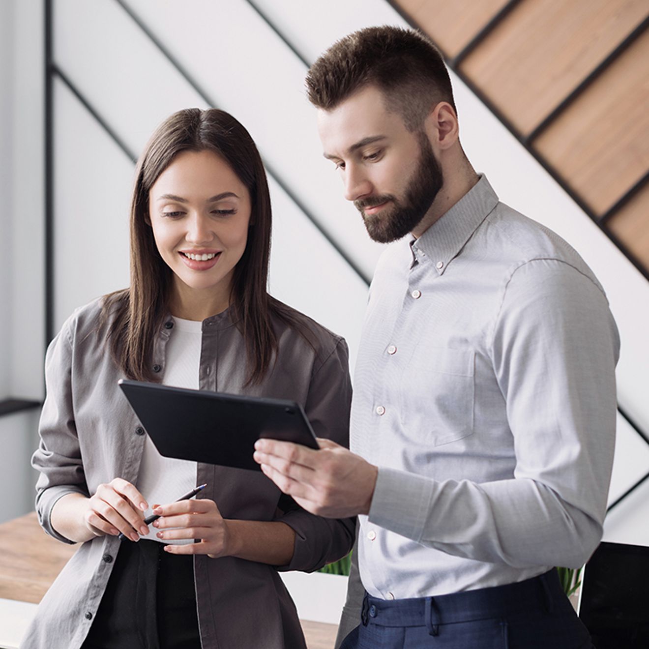 Dos compañeros de trabajo consultando información en una tablet.
