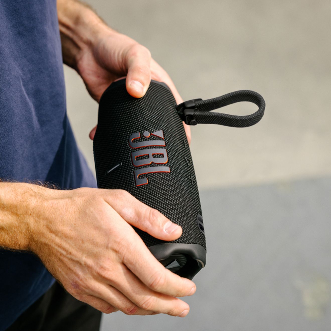 Un hombre sosteniendo un dispositivo JBL Charge