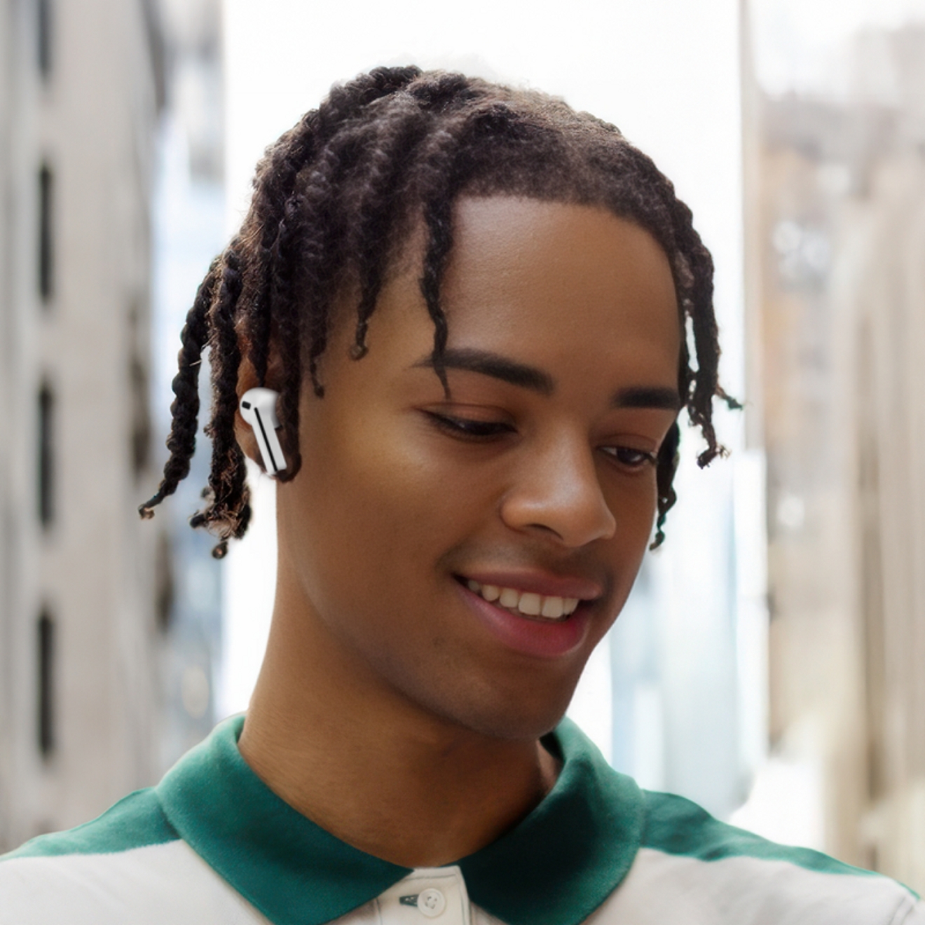 ​​​​​​​Persona usando los Galaxy Buds3 FE en exteriores en una gran ciudad.