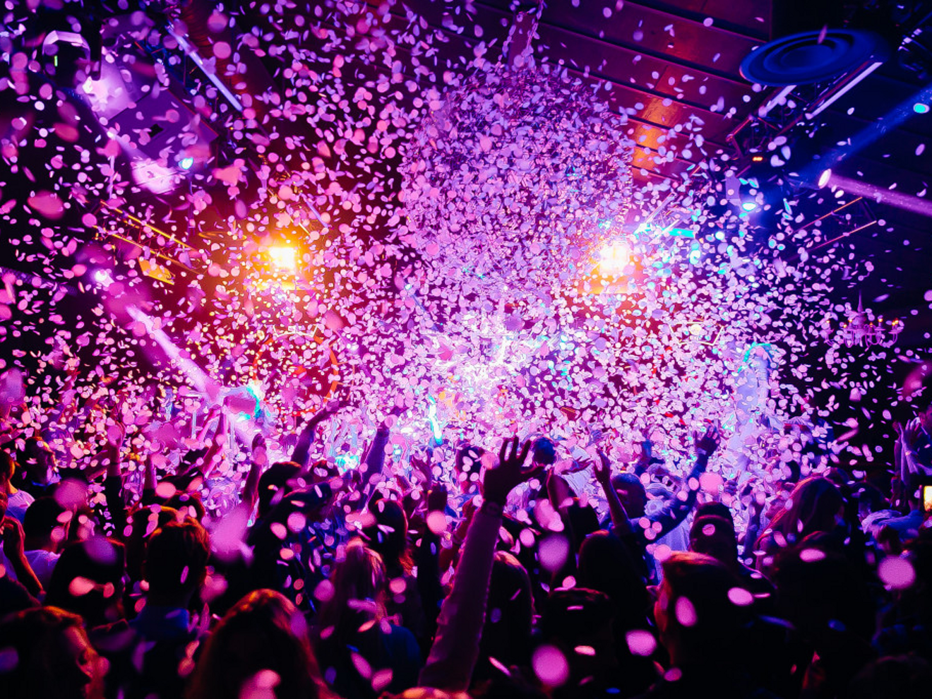 Grupo de personas celebrando con confeti cayendo desde arriba.