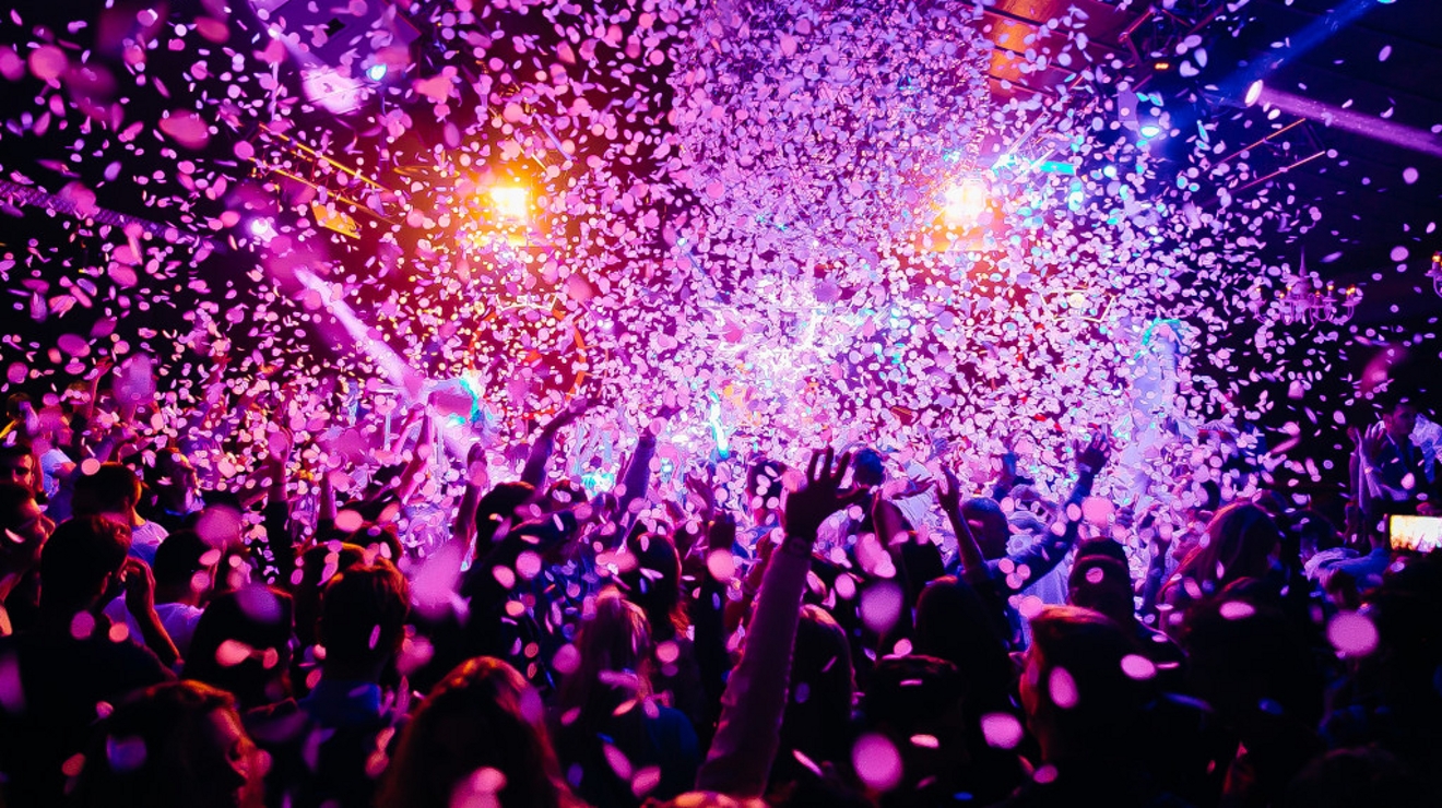 Grupo de personas celebrando con confeti cayendo desde arriba.