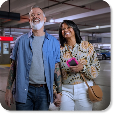 Una pareja camina en un estacionamiento de Dollar Car Rental.