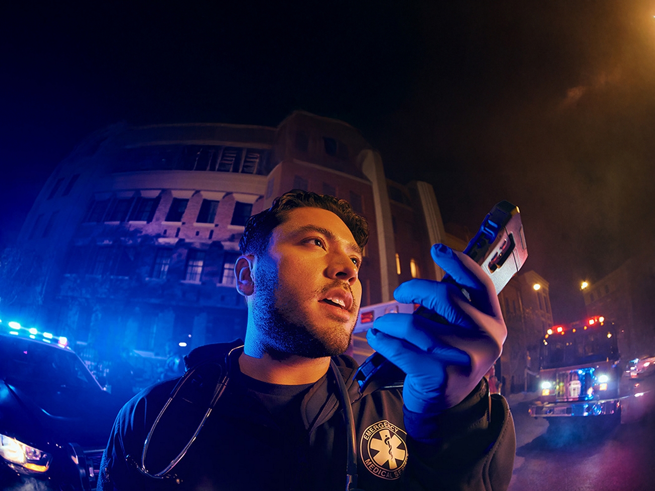 Un técnico de emergencias médicas en el lugar de una emergencia se comunica a través de su smartphone conectado a 5G.